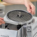 A person using an AvaMix Continuous Feed Food Processor to slice potatoes.