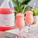Two glasses of pink Narvon cotton candy slushy with straws.