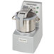 A Robot Coupe stainless steel food processor with a silver lid.