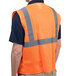 A man wearing a Cordova orange high visibility safety vest with reflective stripes.