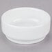 An Arcoroc white porcelain stackable bowl on a gray surface.
