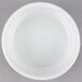 An Arcoroc white porcelain bowl on a gray surface.