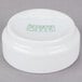 An Arcoroc white porcelain bowl with green writing on it.