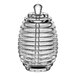 A clear acrylic jar with a spiral design and lid with a honey dipper inside.