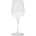 A close-up of a clear GET Social Club Tritan plastic wine glass with a stem.