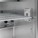 A Hoshizaki sandwich top prep refrigerator with metal shelves and racks.