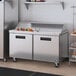 A Hoshizaki stainless steel sandwich top prep refrigerator on a white counter.