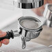 A hand using a Lavazza espresso machine to make coffee.