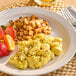 A plate of Eat Just Egg scrambled eggs with fruit on a table.