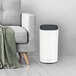 A white Guardian Technologies air purifier next to a gray couch.