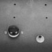 A black and white round knob with a metal object.