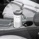 A white and grey Guardian Technologies portable air purifier on a car console.