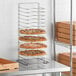 A GI Metal pizza rack holding several pizzas.