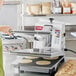 A woman using an Estella Dual-Heat Manual Clamshell Tortilla Dough Press to make tortilla dough.