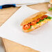 Choice newsprint sandwich wrap paper used to wrap a sandwich with tomatoes and lettuce.