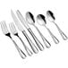 A close-up of a silverware set including Acopa stainless steel dinner spoons.