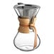 An Acopa glass coffee maker with a wood collar.