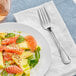 A plate of fruit salad with an Acopa stainless steel salad fork.