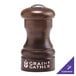 A close-up of a Chef Specialties walnut pepper shaker with a silver top.