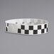 A black and white checkered Carnival King wristband.