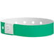 A green and white Carnival King wristband with holes.