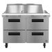 A Hoshizaki stainless steel refrigerated sandwich prep table with four drawers in a large stainless steel commercial kitchen.