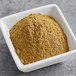 A white bowl of brown Regal Ground Oregano powder.