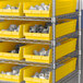 A metal shelving unit with yellow Regency shelf bins.