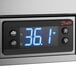 A digital display of a temperature on a Beverage-Air stainless steel sandwich prep table.