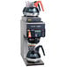 A Bunn Axiom DV-3 coffee brewer on a counter with two coffee pots on top.