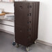 A brown plastic Cambro double compartment tray and sheet pan carrier on wheels.