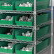 A shelf with green Regency shelf bins.