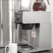 A Bloomfield Koffee King pourover coffee brewer on a counter with a cup underneath.