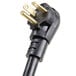 A close-up of a black power plug with two gold prongs.