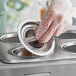 A gloved hand holding a Choice stainless steel bain marie cover.