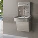 A Zurn water fountain with a light gray water dispenser over a sink.