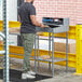 A man standing at a grey metal Lavex stationary receiving desk looking at a computer.