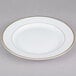 A CAC white porcelain plate with a gold rim.