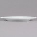 A CAC Golden Royal bright white porcelain plate with a rim on a gray surface.
