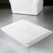 A white Rubbermaid polyethylene lid on a table.
