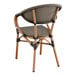 A brown outdoor arm chair with a wicker back and wooden frame.