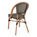 A Lancaster Table & Seating brown Teslin outdoor side chair with a black back and seat.