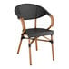 A Lancaster Table & Seating black outdoor arm chair with wooden legs and a black Teslin seat.