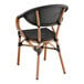 A Lancaster Table & Seating black outdoor arm chair with a black seat and wood accents.