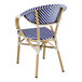 A Lancaster Table & Seating blue and white striped outdoor arm chair with a wooden frame.