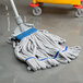 A blue and white Unger SmartColor heavy duty microfiber string mop head on the floor.