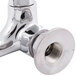 A chrome Equip by T&S wall mounted faucet with lever handles and a swing spout.