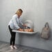 A woman using a Koala Kare gray horizontal baby changing station to change a baby.