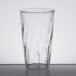 A close-up of a clear Carlisle polycarbonate tumbler with a wavy design.