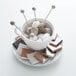 An Arcoroc saucer with a cup of coffee and marshmallow sticks on a table.